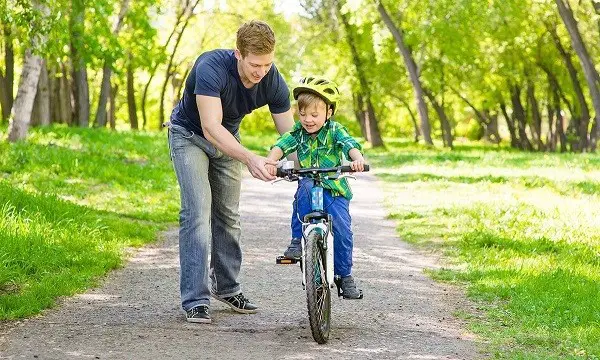bir çocuğu iki tekerlekli bir bisiklete bindirmek